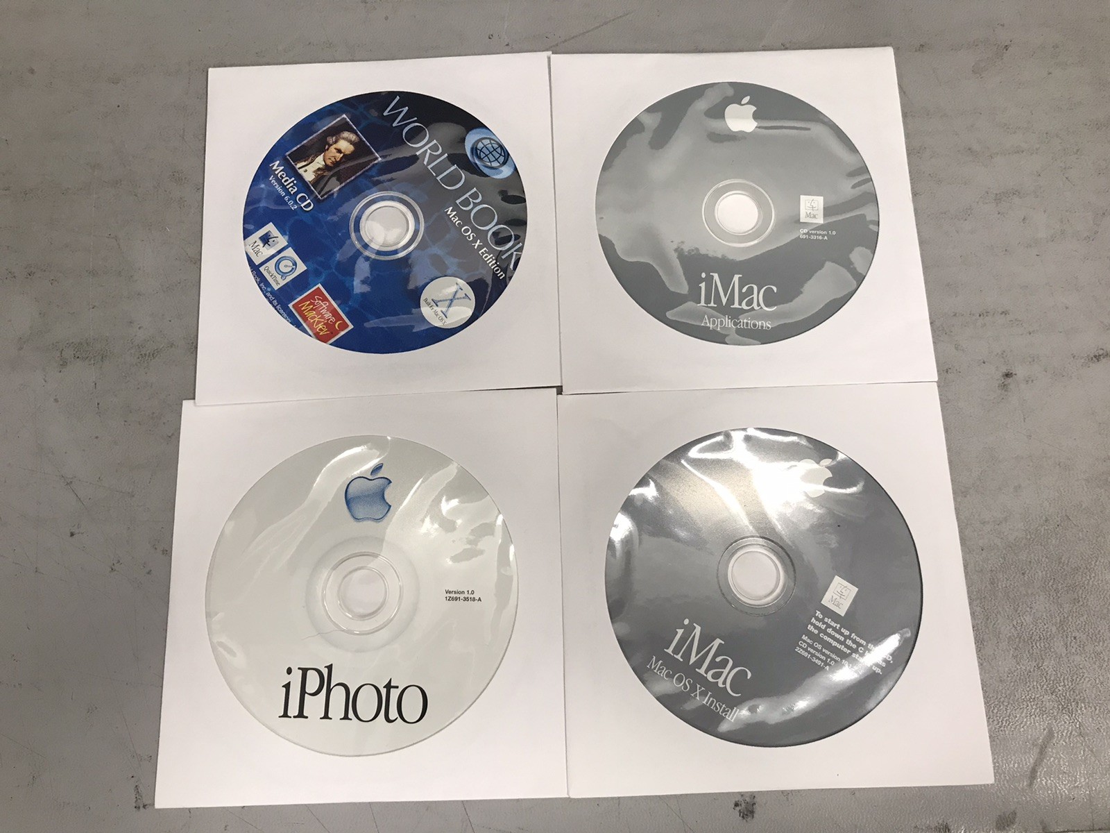 Lot Of 4 Assorted Apple MacOS CDs – iPhoto, OSX Install, OSX Apps, World Book